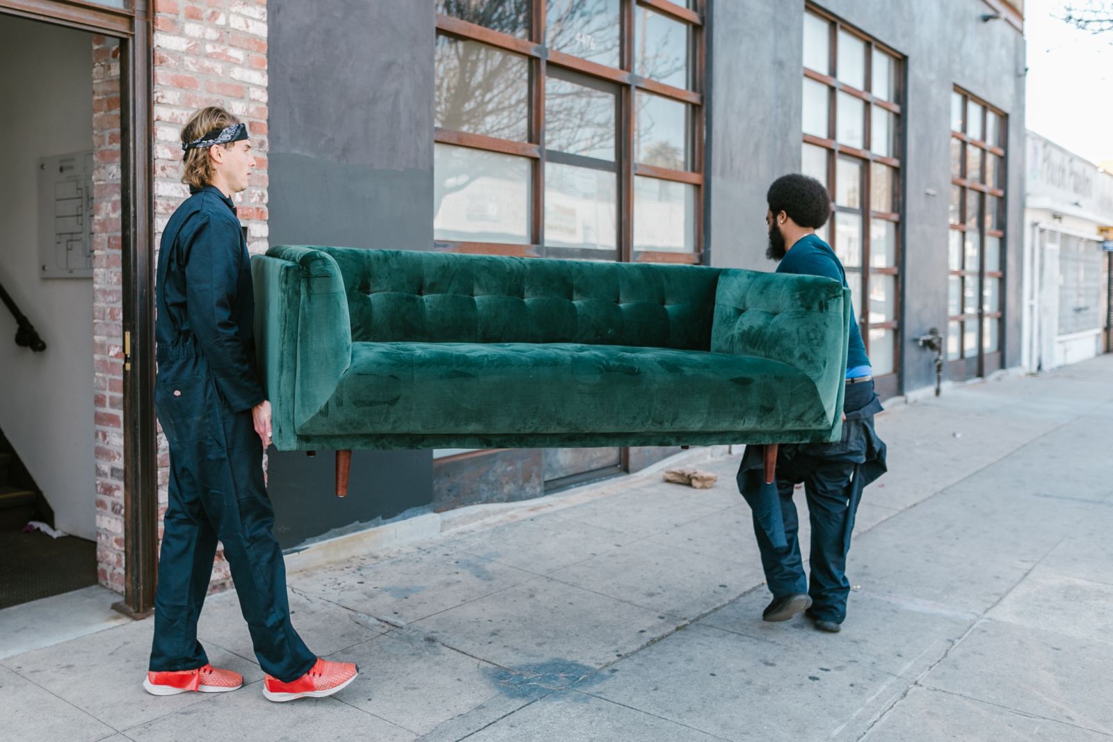 Junk removal crew carrying an old sofa out to the truck in Elk Grove, CA