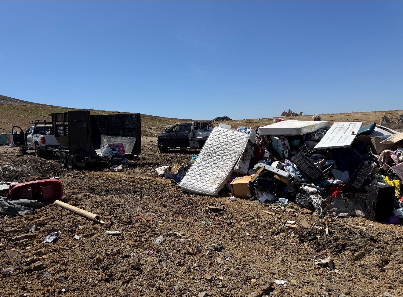 Junk removal truck and dump trailer unloading a full load at the Sacramento County landfill
